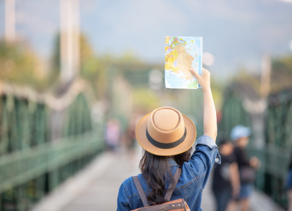 Female tourists on hand have a happy travel map.