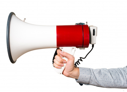 Hand of man holding shouting by megaphone