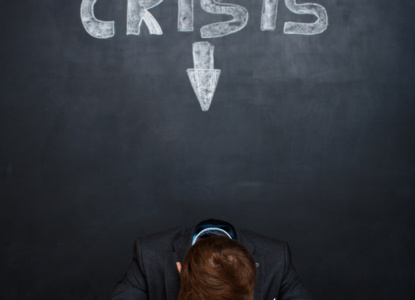 Picture of tired man over blackboard with crisis inscription